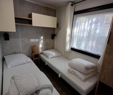 Dans la chambre avec deux lits simples et fenêtre du Mobil home 6 personnes 3 chambres