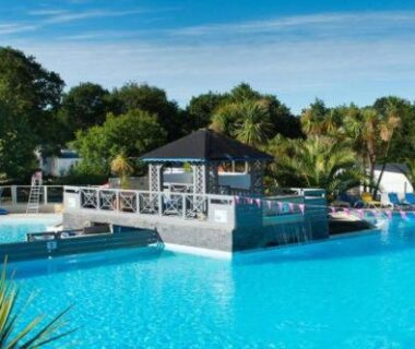 Piscine du camping avec kiosque et palmiers au Mobil home 6 personnes 3 chambres