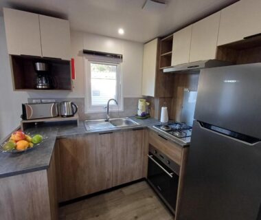 Cuisine équipée avec réfrigérateur four évier et micro-ondes dans le Mobil home 6 personnes 3 chambres