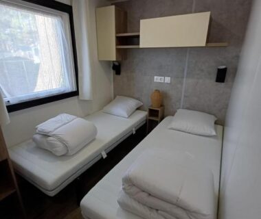 Chambre avec deux lits simples dans le Mobil home 6 personnes 3 chambres