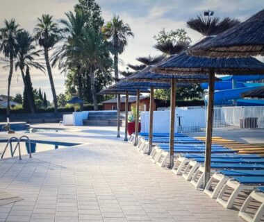 Piscine extérieure bordée de transats et parasols au Mobil home 6 personnes