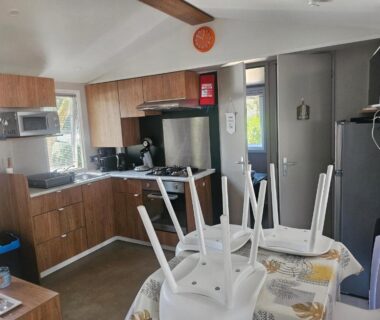 Cuisine équipée et table avec chaises retournées dans le mobil home 6 personnes