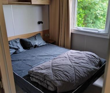 Chambre avec lit double et fenêtre sur la verdure du mobil home Amorosa0066