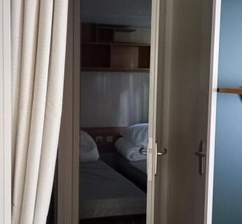 Couloir et chambre visibles dans le mobil home 6 personnes du Camping SIBLU le Bois de Bayadène
