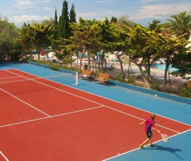 Terrain de tennis avec joueur près des cyprès au Mobil-home 6 personnes Clim Camping Mar Estang