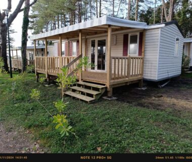 Dans un bosquet de pins terrasse en bois devant le Mobil home 6 personnes Mer et Pins