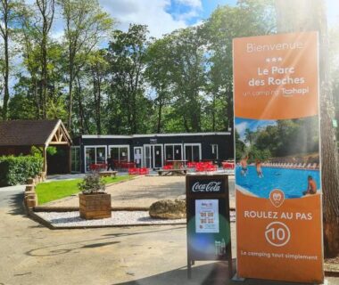 Entrée du camping avec panneau d'accueil et terrasse au Mobil-home 6 personnes climatisé le Miami zen