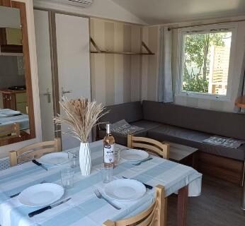 Intérieur coin repas et salon lumineux du Mobil home 6 personnes confort Océan climatisé camping avec piscine Agde