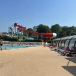 Piscine extérieure avec toboggans et transats du Mobil home 6 personnes dans camping 5 étoiles