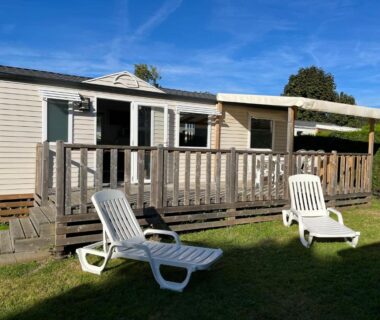Terrasse en bois avec transats sur pelouse du mobil home 6 personnes