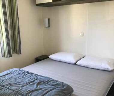 Chambre avec lit double et étagère dans le Mobil home 6 personnes du camping 5 étoiles