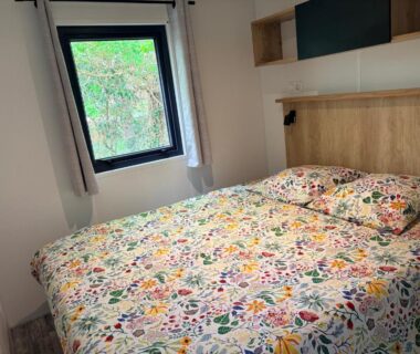 Intérieur chambre double avec lit fleuri dans le Mobil home 6 personnes premium