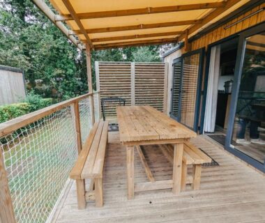 Terrasse couverte en bois avec table et bancs du Mobil home 6 personnes premium