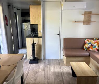 Intérieur salon avec canapé kitchenette et climatisation du Mobil home 6 personnes premium
