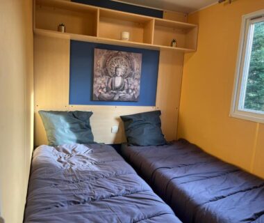 Chambre avec deux lits simples et fenêtre dans le mobil home 6 personnes puy du fou