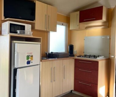 Cuisine compacte avec réfrigérateur micro-ondes et plan de cuisson dans le mobil home 6 personnes Puy du Fou