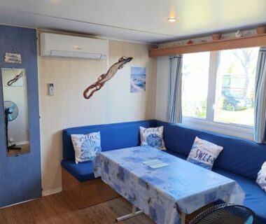 Salon avec banquette et table dans le mobil home 6 place a 900 mètres de la plage