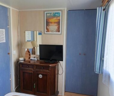 Intérieur avec lit armoire et meuble TV du Mobil home 6 place à 900 mètres de la plage
