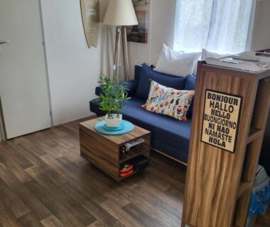 Intérieur salon avec canapé bleu lampadaire et table basse du Mobil home 6/8 pers Les Dunes de Contis