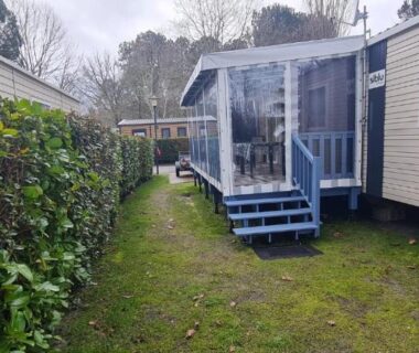 Terrasse couverte et escalier sur pelouse du Mobil home 693 à la réserve 8 personnes