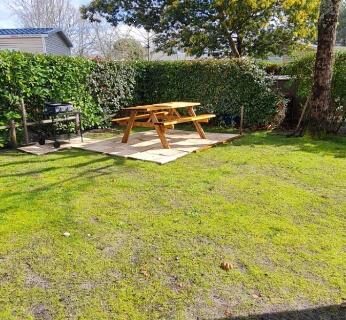 Terrasse dans le jardin avec table en bois du Mobil home 693 à la réserve