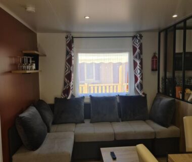 Salon avec banquette et fenêtre dans le Mobil-home