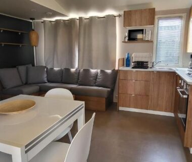 Séjour avec table à manger canapé et kitchenette dans le Mobil home 8 personnes
