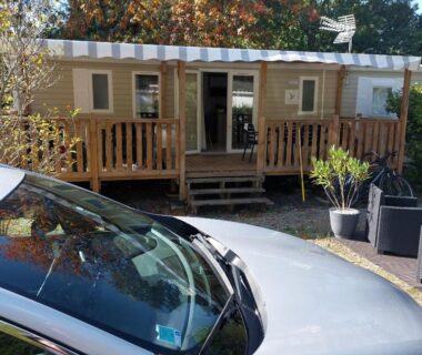 Terrasse en bois avec voiture garée devant le mobil home 8 personnes 3 chambres