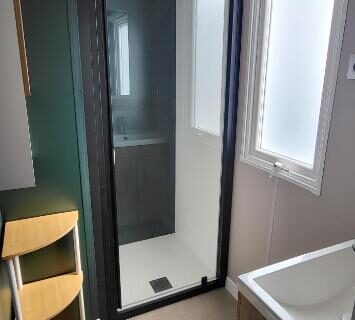 Salle d'eau avec douche vitrée et fenêtre du mobil home 8 personnes