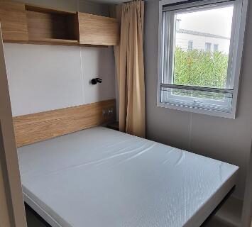 Chambre avec lit et fenêtre dans le Mobil home 8 personnes