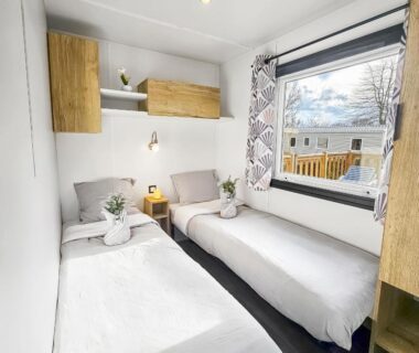 Chambre avec deux lits et fenêtre donnant sur le parc dans le Mobil home 8 personnes Confort et Tranquillité