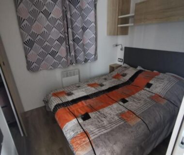 Chambre avec lit double et rideaux dans le mobil-home 8 places du camping Kerlann