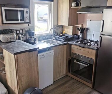 Cuisine équipée avec évier plaques four et réfrigérateur du mobil-home 8 places camping kerlann