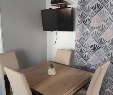 Intérieur avec table, chaises et télévision du Mobil-home 8 places camping Kerlann