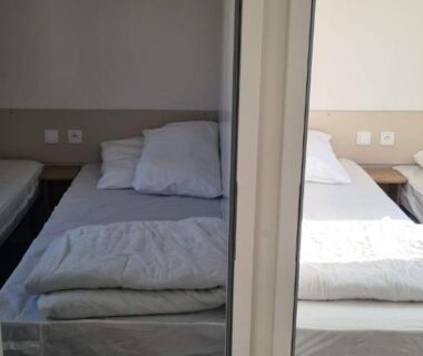 Chambre avec deux lits et armoire miroir dans le mobil home Amira 3 Trigano