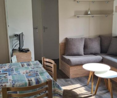 Intérieur salon et coin repas avec canapé et table dans le Mobil home Amira 3 Trigano