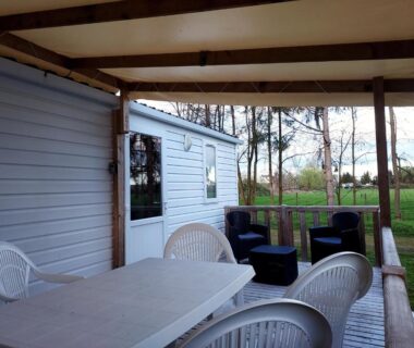Terrasse couverte avec mobilier de jardin et vue sur la pelouse du Mobil-home C007 - C008