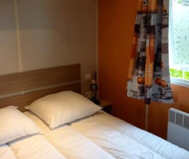 Chambre avec lit double et fenêtre dans le mobil home CARNAC