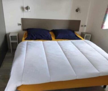 Chambre avec lit double et chevets dans le mobil home Camping La Marine