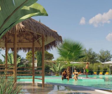 Piscine extérieure avec paillote et palmiers au Mobil home Camping La Marine