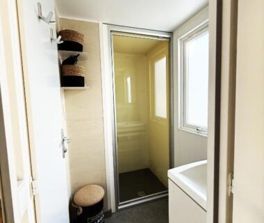 Salle de bain avec cabine de douche et lavabo du mobil-home Le Marisol