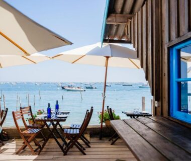 Terrasse en bord de mer avec parasols et tables au Mobil home Camping Les Embruns 4 étoiles