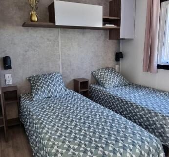 Chambre avec deux lits simples et rangements dans le mobil-home Camping Les Oyats 4 Etoiles