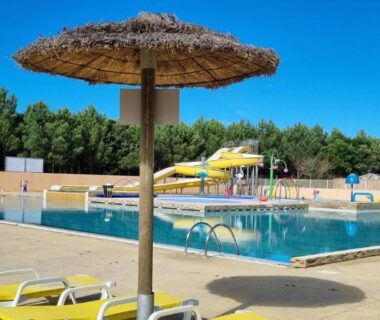 Bord de piscine avec parasols transats et toboggan du Mobil-home Camping Les Oyats 4 Etoiles