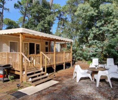 Devant le mobil-home terrasse en bois avec chaises et transats au Mobil-home Camping Les Oyats 4 Etoiles