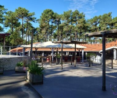 Place centrale ombragée avec parasols et pergolas au Mobil-home du Camping Les Oyats