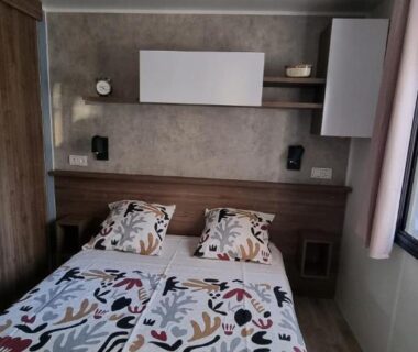 Chambre avec lit double et rangements dans le mobil-home du Camping Les Oyats