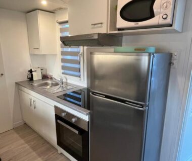 Kitchenette avec réfrigérateur four et micro-ondes dans le Mobil-home Camping Oasis