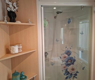 Salle d'eau avec cabine de douche et étagères dans le mobil home Camping Proche ROYAN a 300m de la plage