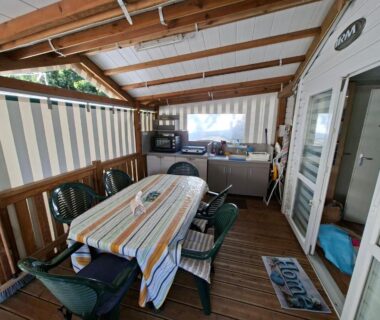 Terrasse couverte avec table et chaises et kitchenette du Mobil home Camping Proche ROYAN a 300m de la plage